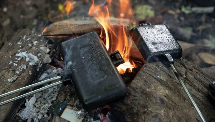 Making toast with a cast iron over a campfire